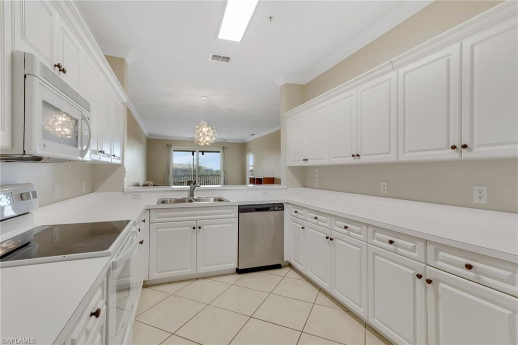 8570 Kingbird Loop, Unit 542 Estero, FL 33967 - Photo 14 of 43 a kitchen with white cabinets sink and white appliances