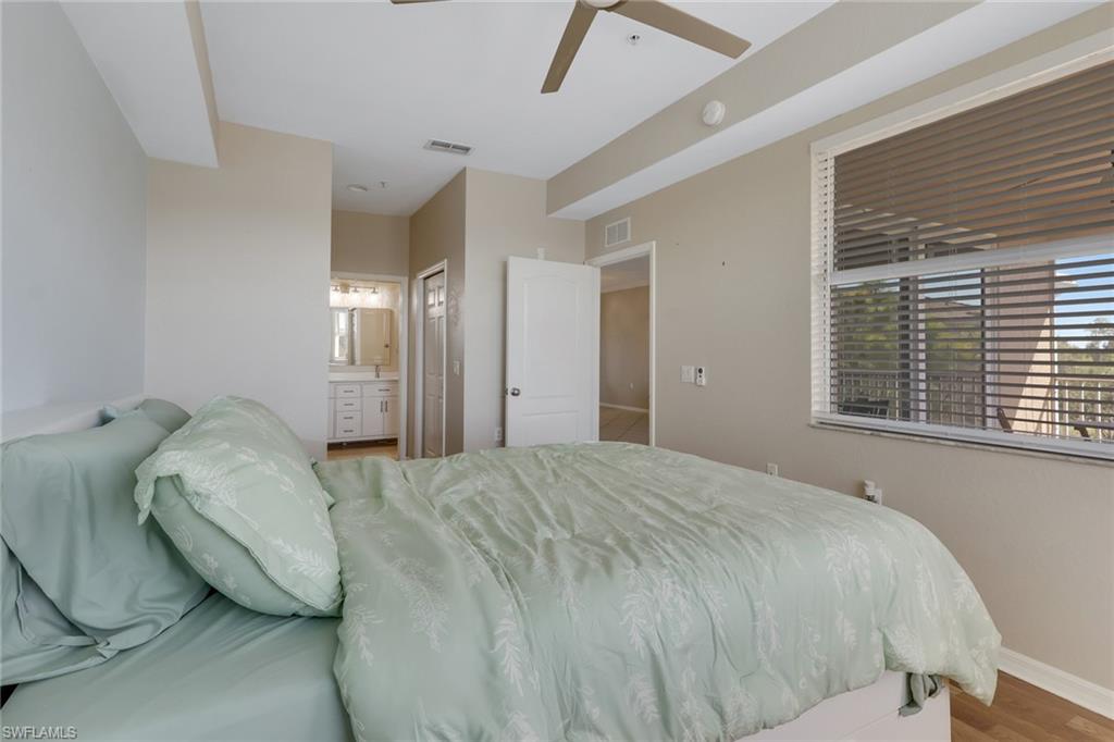 8570 Kingbird Loop, Unit 542 Estero, FL 33967 - Photo 20 of 43 a large bed sitting in a bedroom next to a window and a chandelier