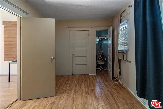 a view of a hallway with wooden floor and closet