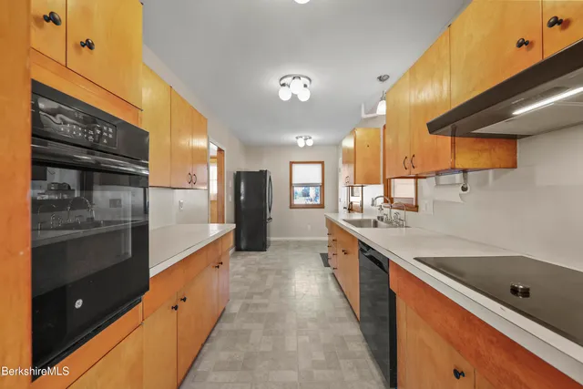 a large kitchen with kitchen island a sink stainless steel appliances and cabinets