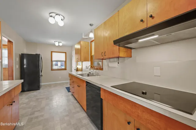 a large kitchen with stainless steel appliances wooden cabinets and a sink