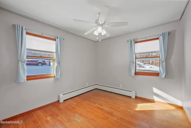 a view of an empty room with chandelier fan and fire place