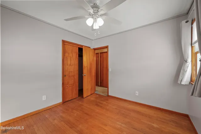 an empty room with windows and fan