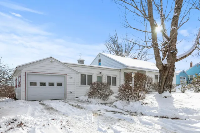 a front view of a house with a yard covered in snow