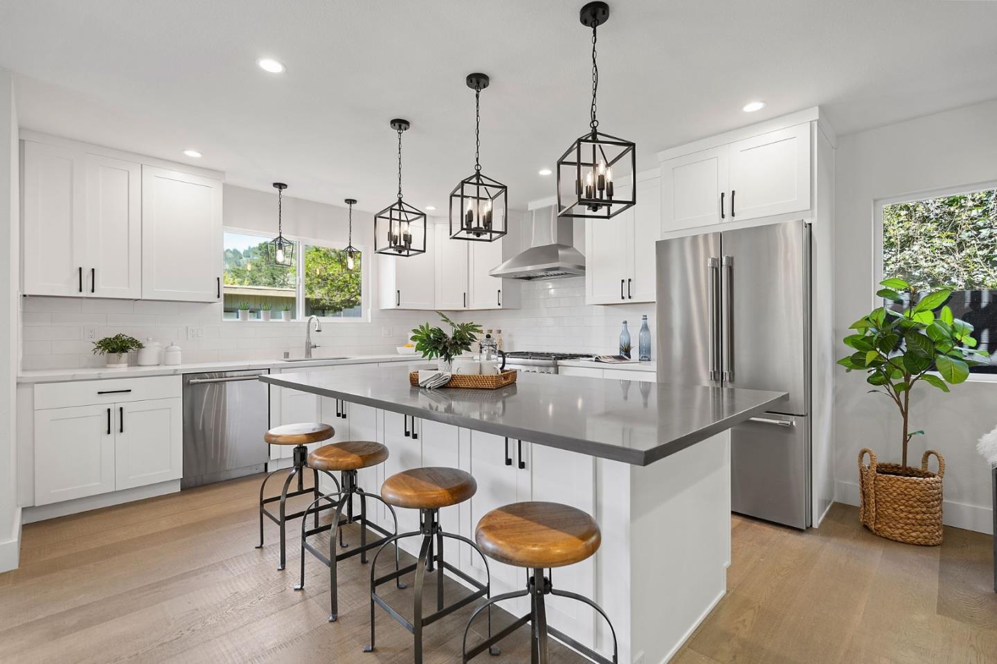 311 Keith Avenue Pacifica, CA 94044 - Photo 14 of 40 a kitchen with stainless steel appliances granite countertop a refrigerator a sink dishwasher a stove a dining table and chairs with wooden floor