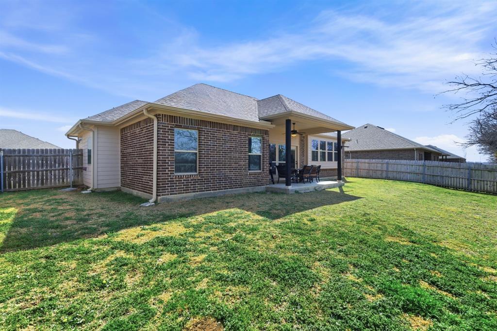 711 Hadley Lane Valley View, TX 76272 - Photo 28 of 40 Back of house featuring a fenced backyard, a patio area, brick siding, and roof with shingles