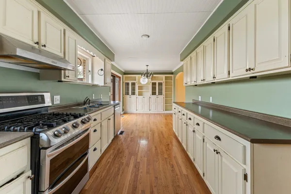 a kitchen with granite countertop a stove and a wooden cabinets