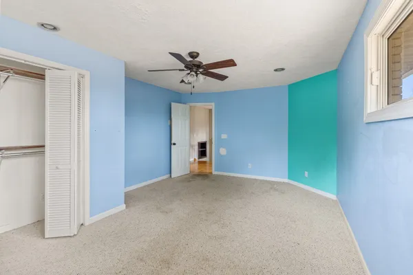 a view of a room with a ceiling fan and a window