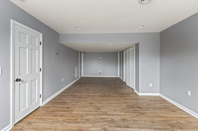 a view of a big room with wooden floor and windows