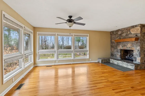 a view of an empty room with a fireplace and a window