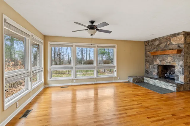 a view of an empty room with a fireplace and a window