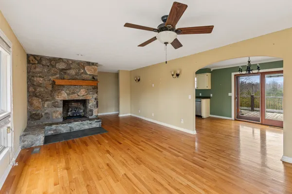 a view of empty room with wooden floor and fireplace