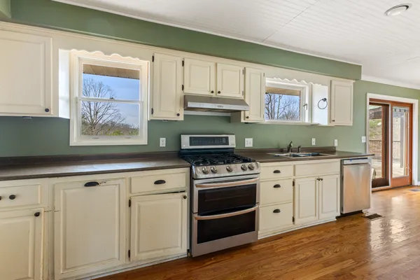 a kitchen with granite countertop white cabinets and stainless steel appliances