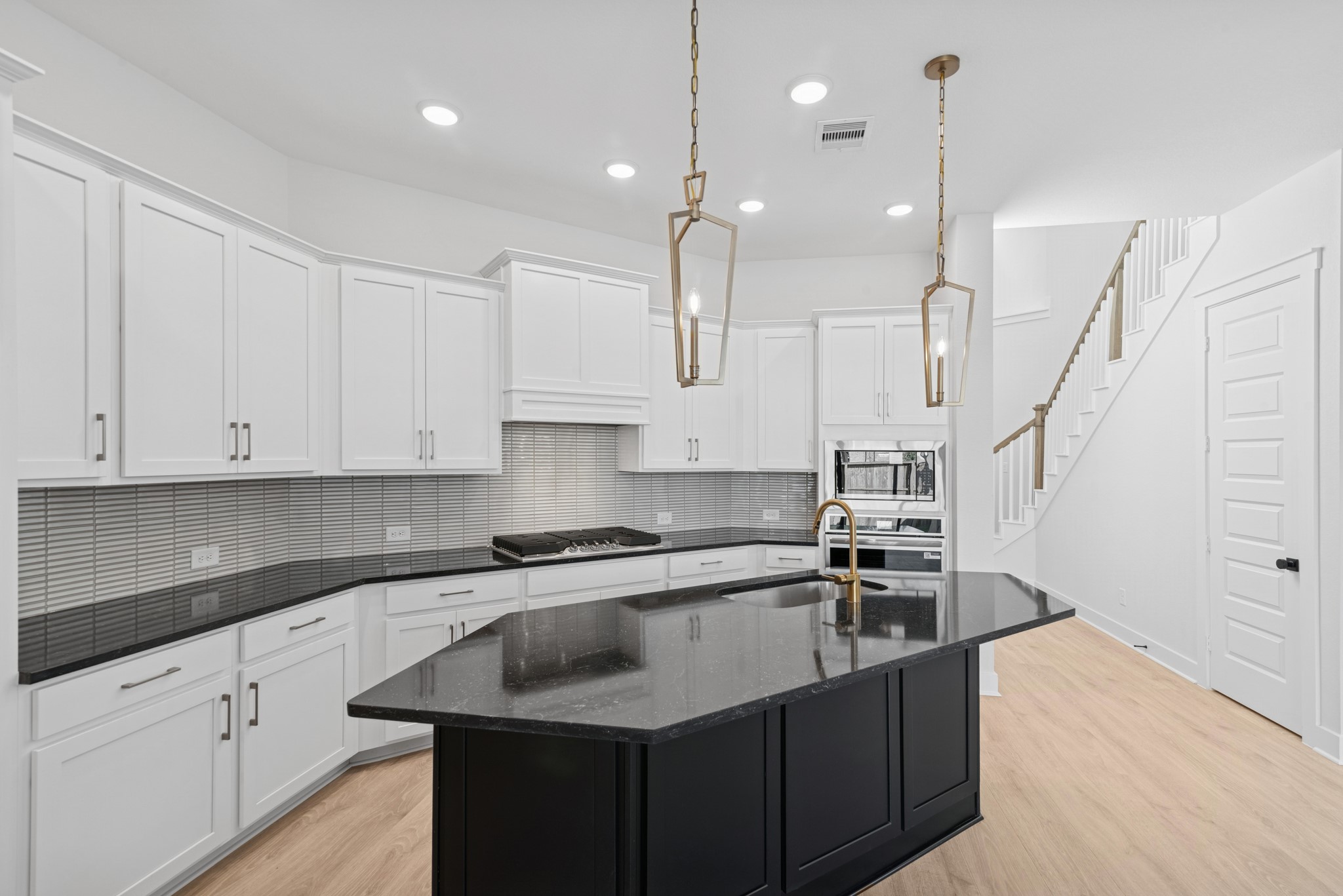 8751 Mancos Valley Porter, TX 77365 - Photo 23 of 48 a kitchen with stainless steel appliances granite countertop a sink a stove and white cabinets with wooden floor