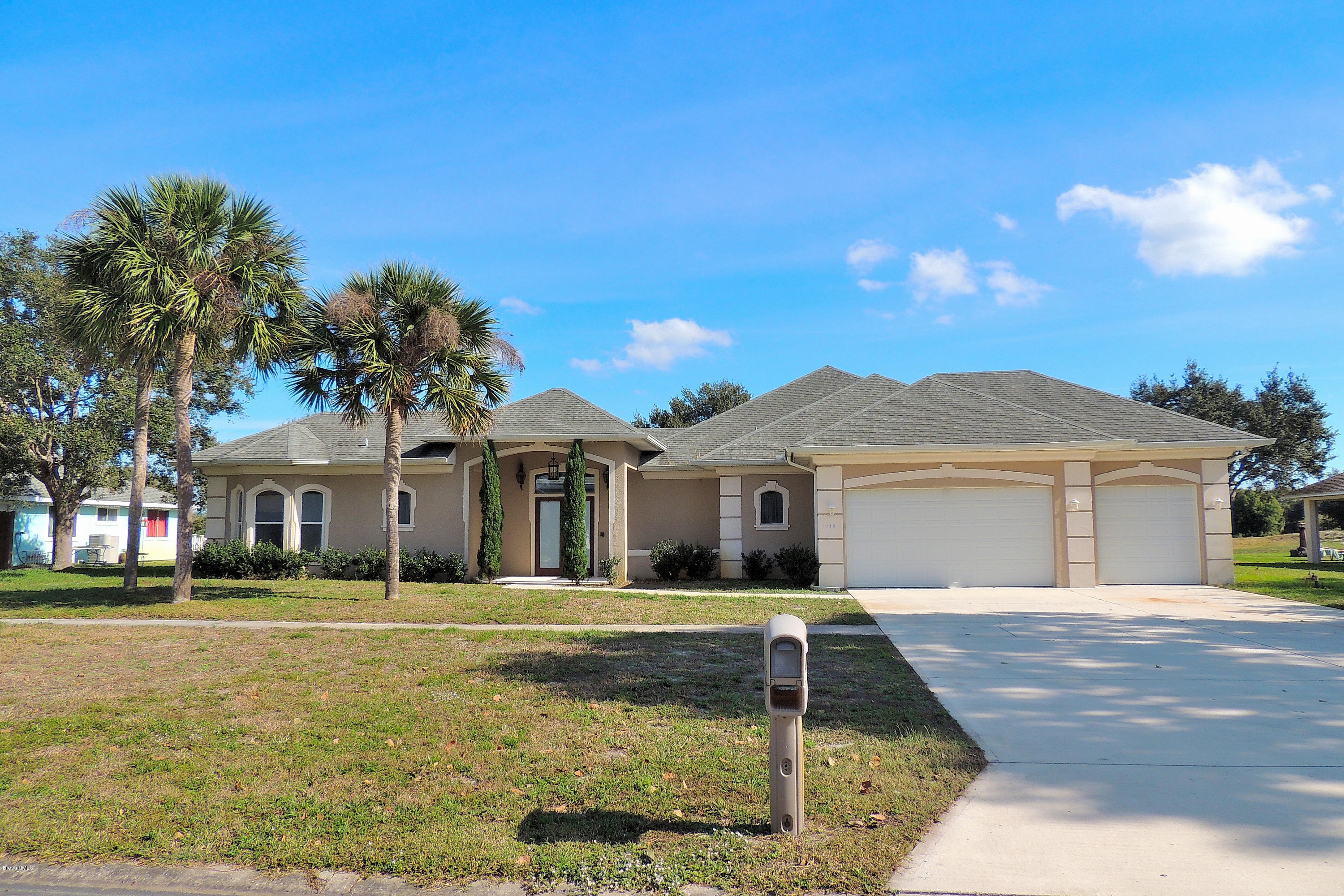 1120 Riviera Drive Northeast Palm Bay, FL 32905 - Photo 1 of 44 a front view of a house with a garden
