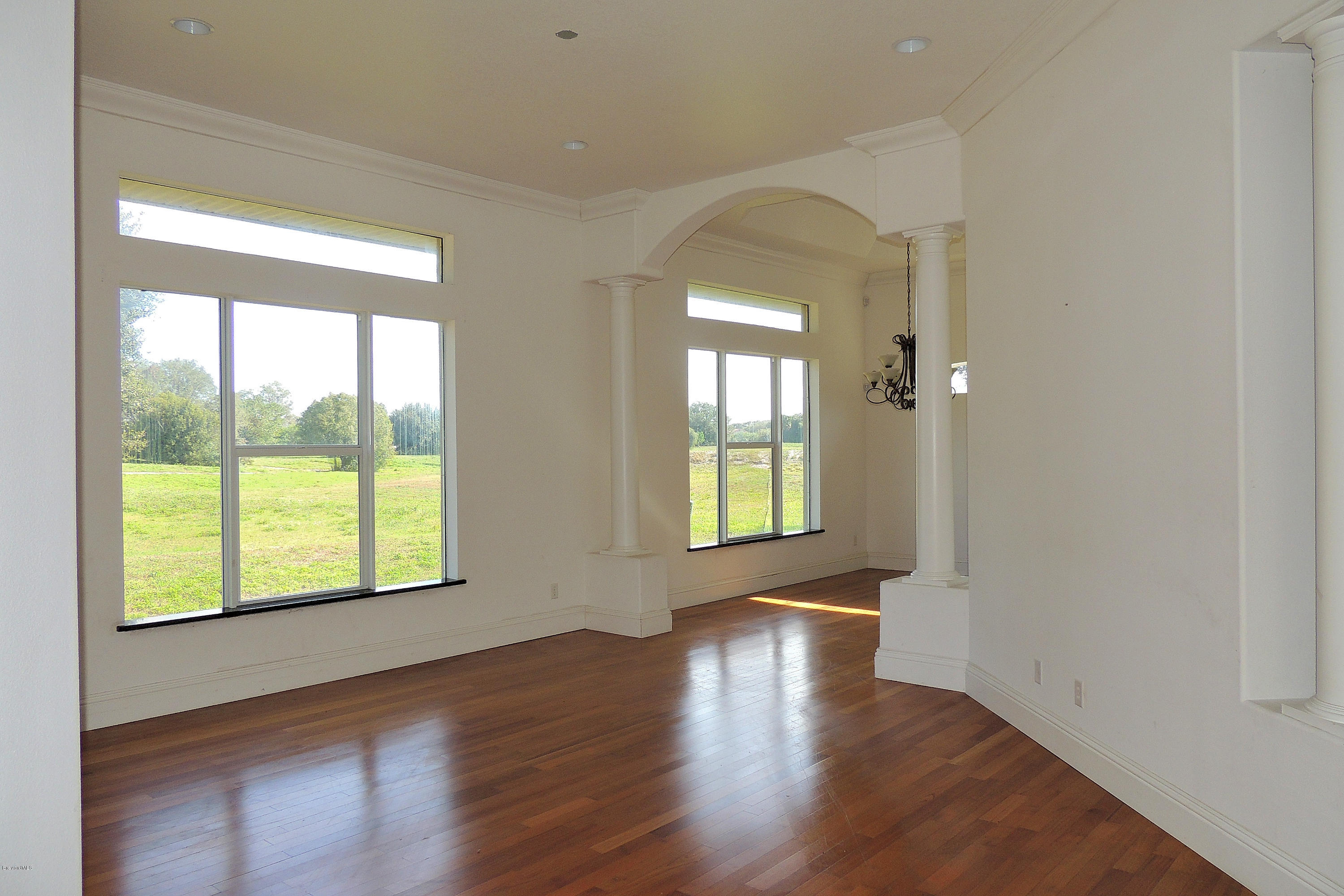 1120 Riviera Drive Northeast Palm Bay, FL 32905 - Photo 17 of 44 an empty room with wooden floor and windows