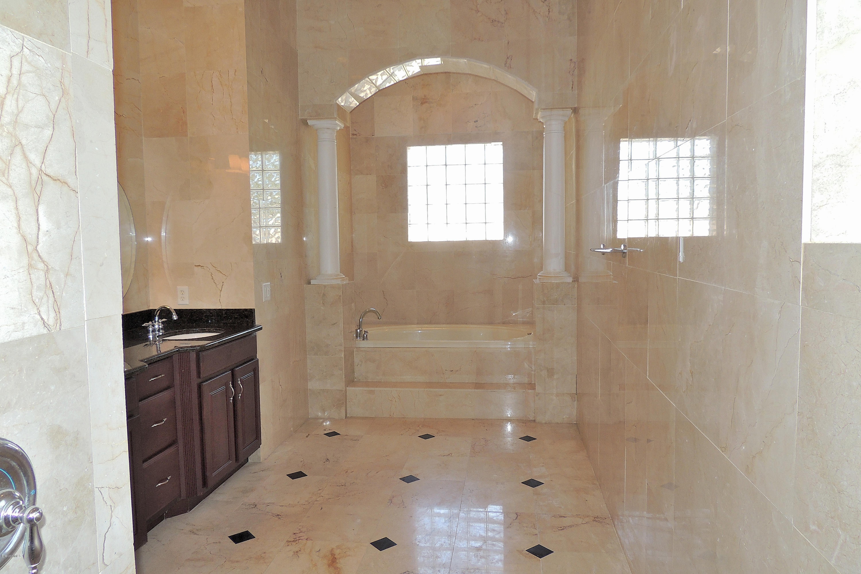 1120 Riviera Drive Northeast Palm Bay, FL 32905 - Photo 23 of 44 a bathroom with double vanity and a bathtub