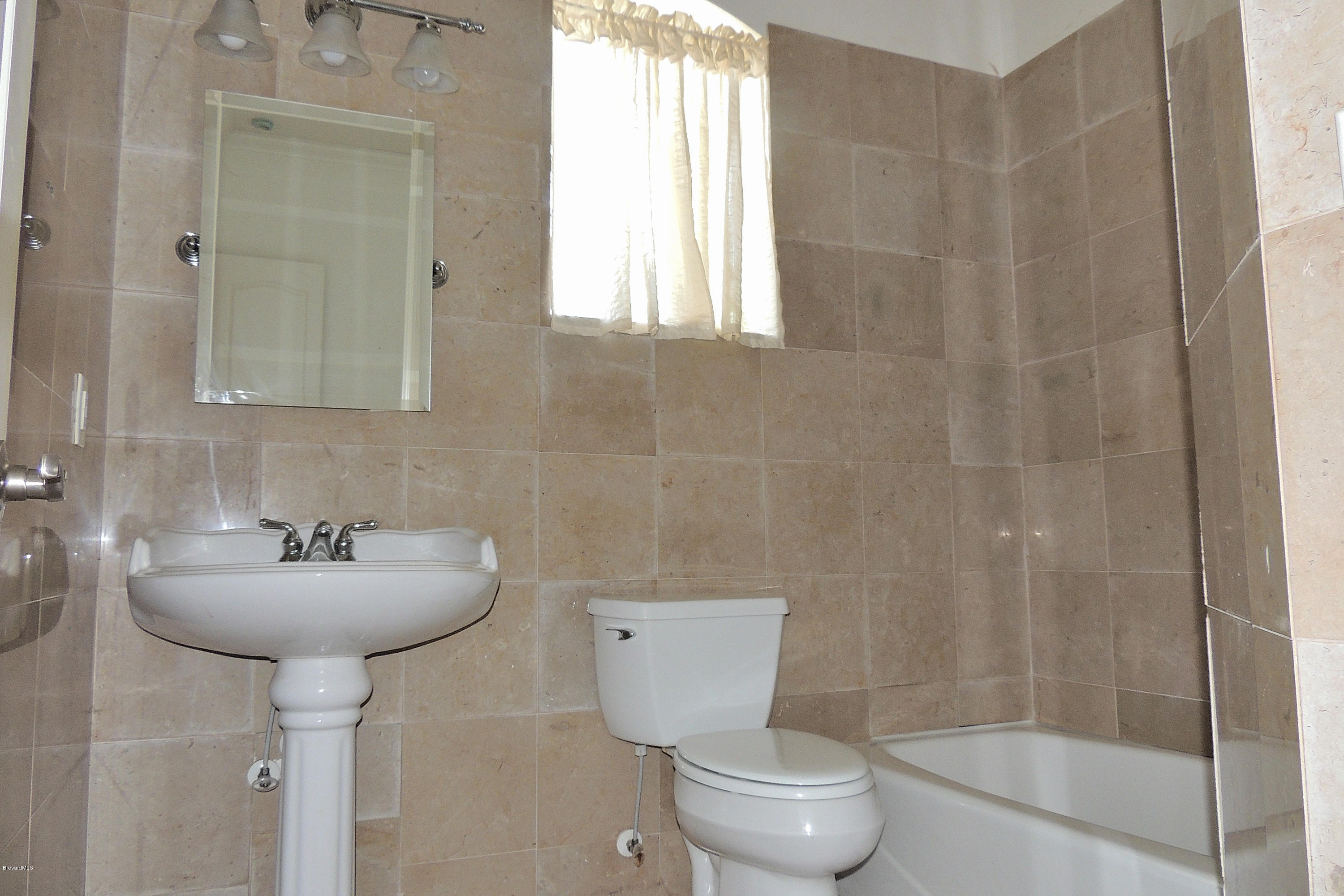 1120 Riviera Drive Northeast Palm Bay, FL 32905 - Photo 26 of 44 a bathroom with a sink toilet and shower