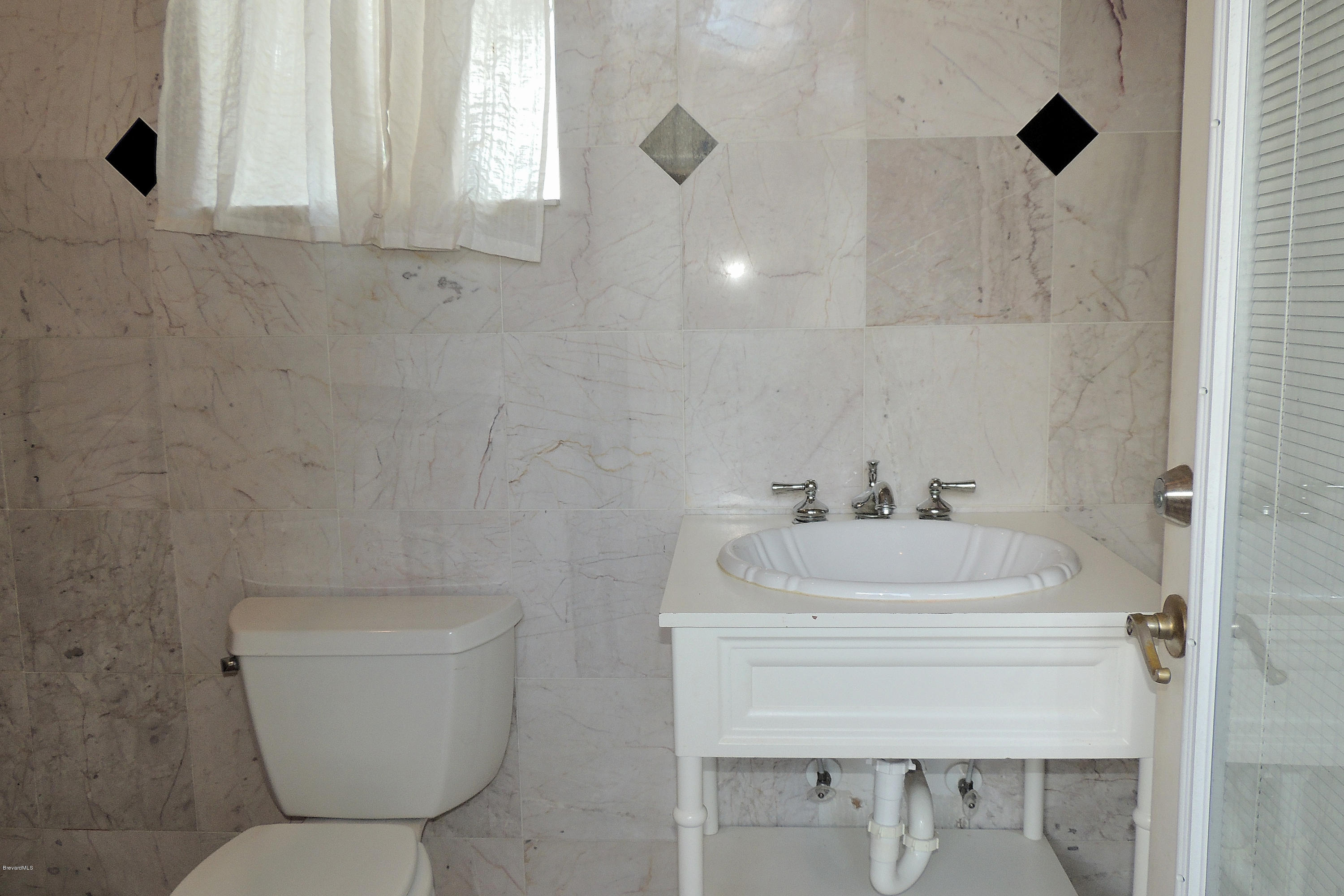 1120 Riviera Drive Northeast Palm Bay, FL 32905 - Photo 30 of 44 a bathroom with a sink a toilet and a mirror