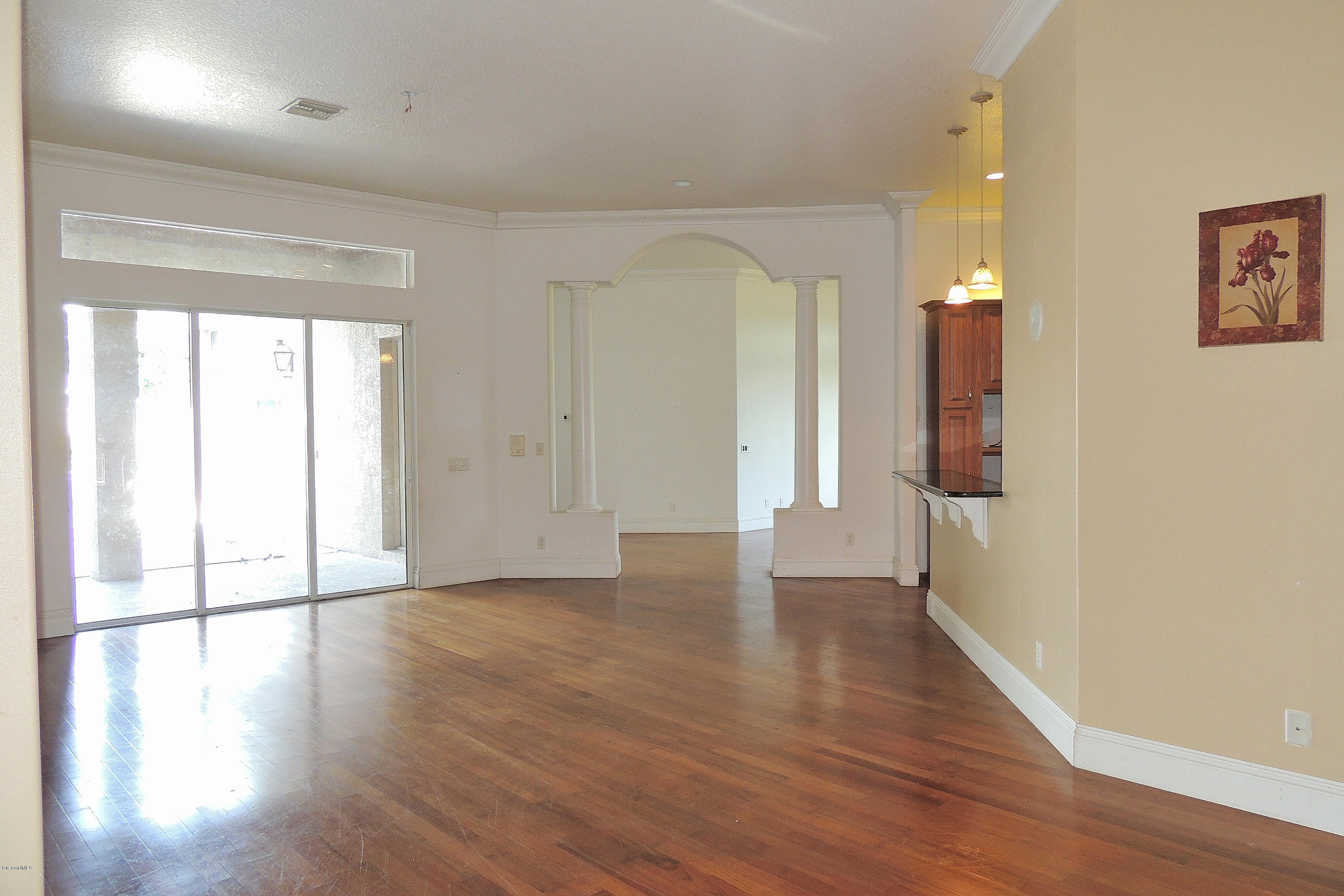 1120 Riviera Drive Northeast Palm Bay, FL 32905 - Photo 5 of 44 a view of an empty room with wooden floor and a window