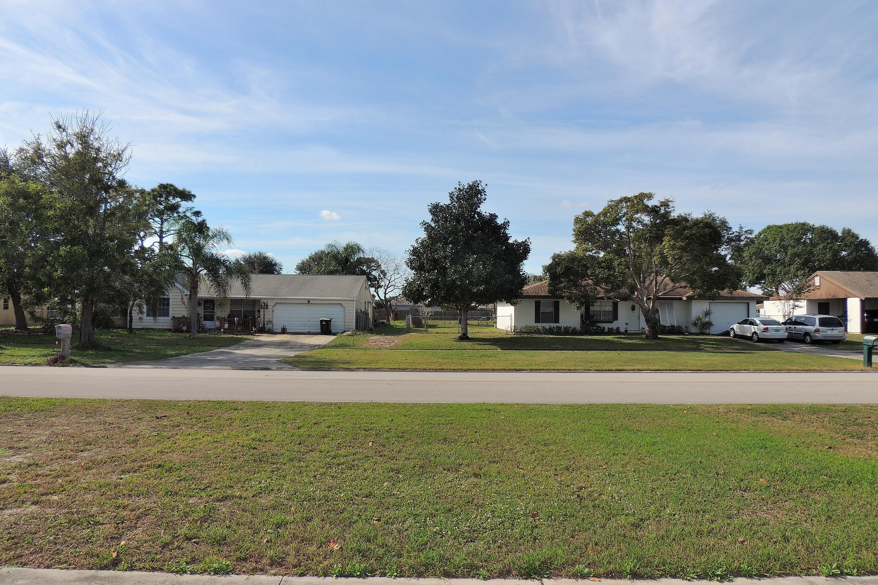 1120 Riviera Drive Northeast Palm Bay, FL 32905 - Photo 43 of 44 a house view with swimming pool and trees in the background