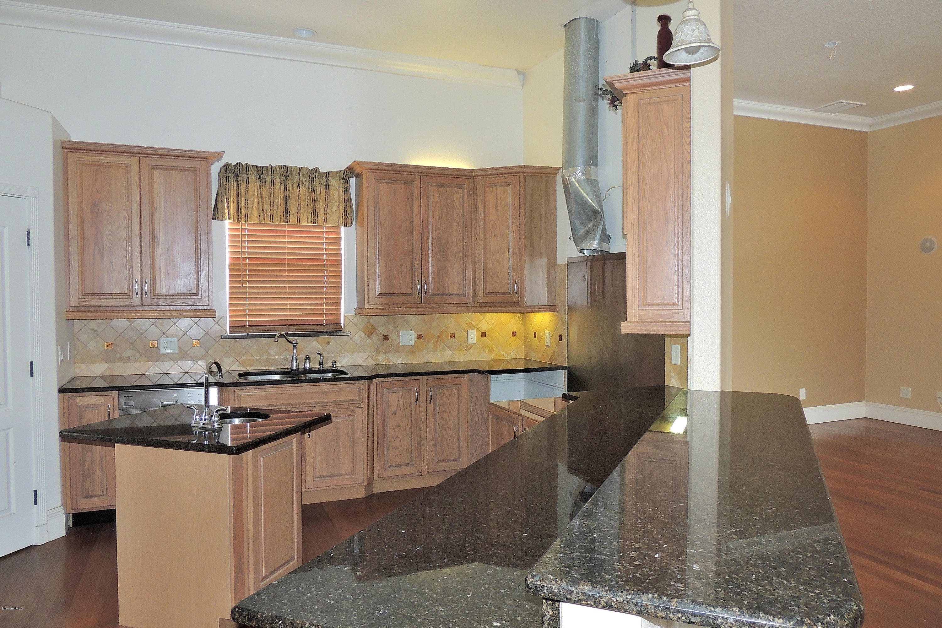 1120 Riviera Drive Northeast Palm Bay, FL 32905 - Photo 7 of 44 a kitchen with granite countertop a sink and a stove