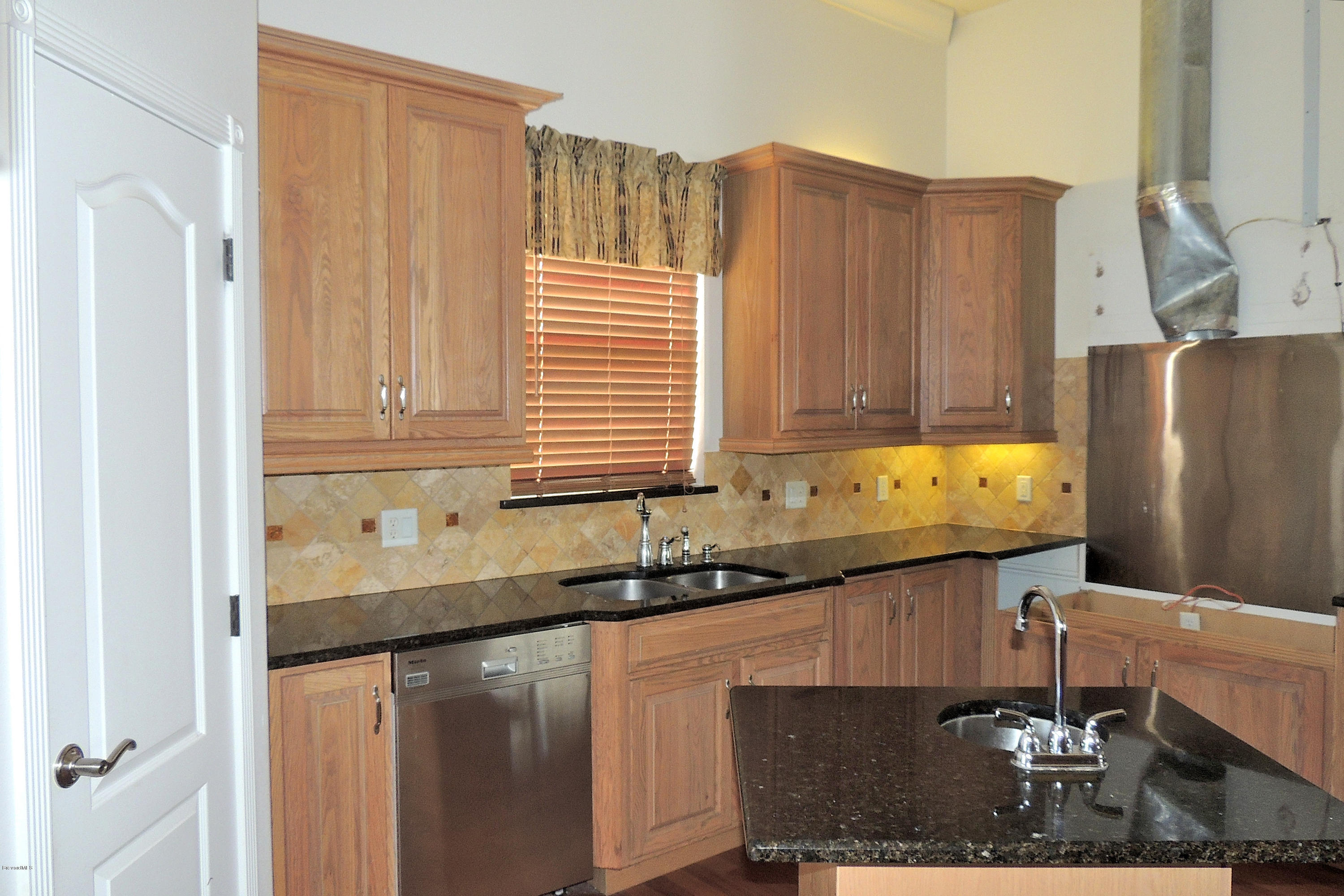 1120 Riviera Drive Northeast Palm Bay, FL 32905 - Photo 9 of 44 a kitchen with granite countertop a sink a refrigerator and a cabinets
