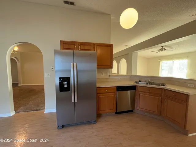 a kitchen with stainless steel appliances granite countertop a refrigerator and a sink