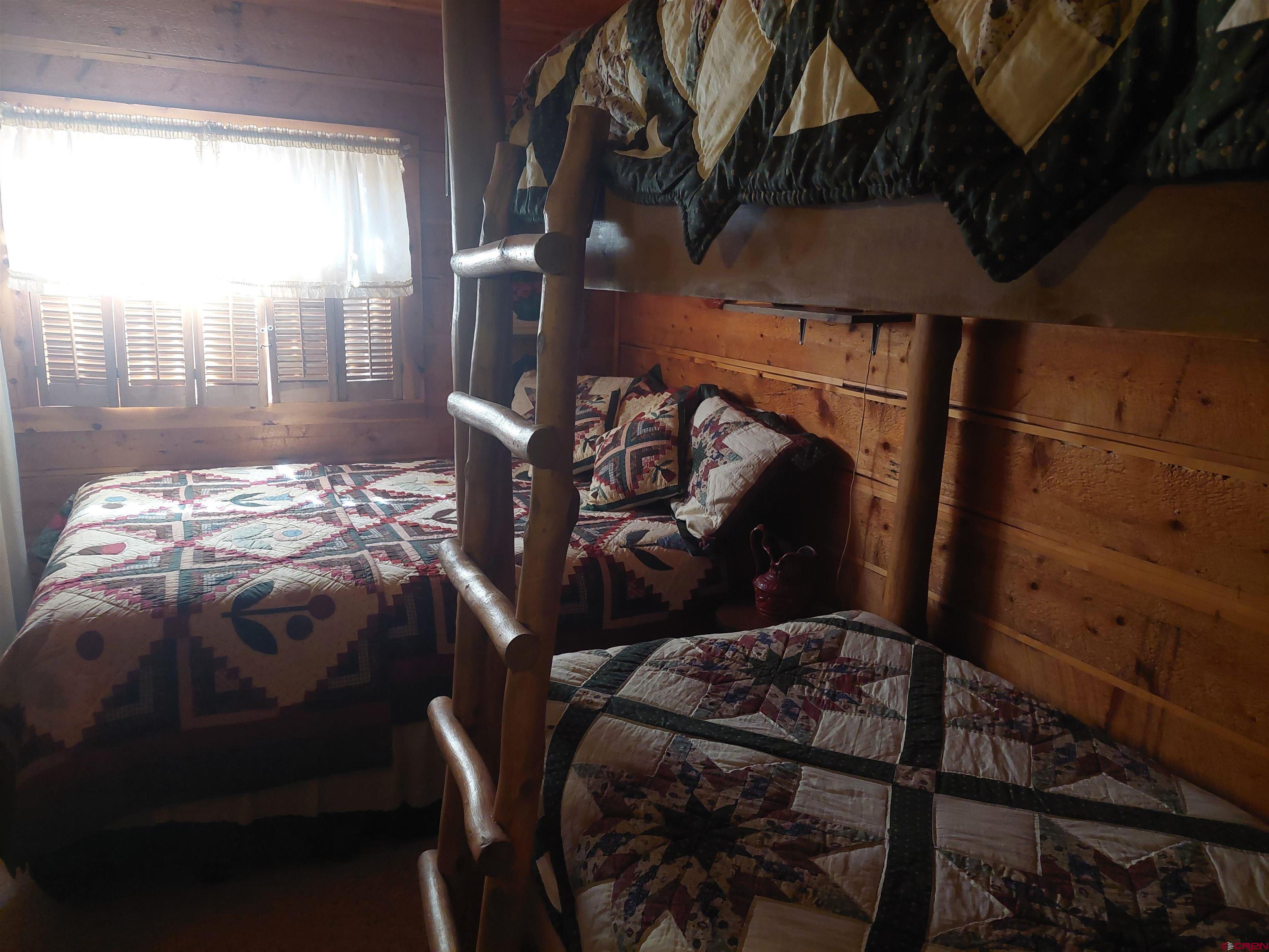 813 Milner Pass Road South Fork, CO 81154 - Photo 11 of 27 a bed sitting in a bedroom next to a window