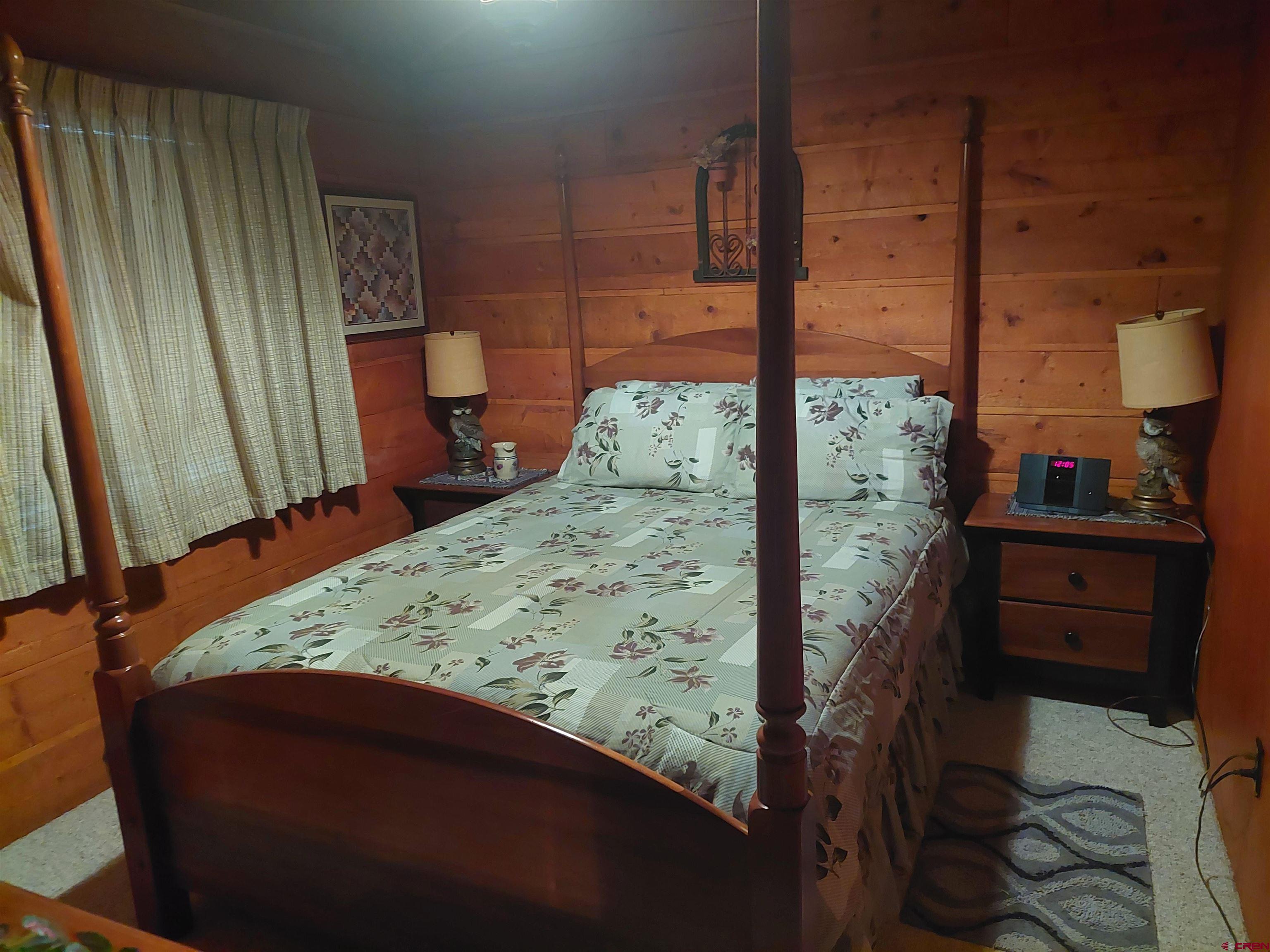813 Milner Pass Road South Fork, CO 81154 - Photo 9 of 27 a bedroom with a bed and wooden floor