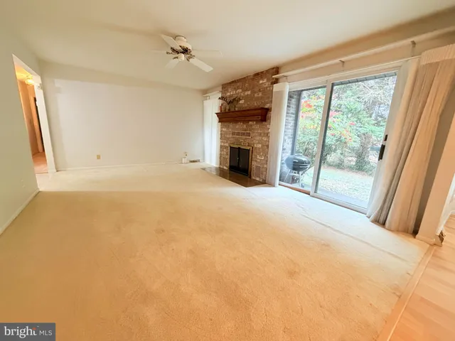 a view of an empty room with a fireplace and a window