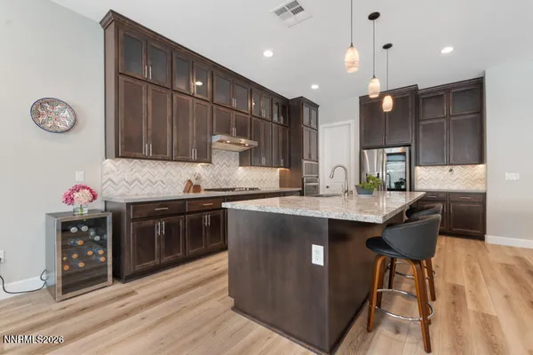a kitchen with stainless steel appliances granite countertop a sink a stove and a refrigerator