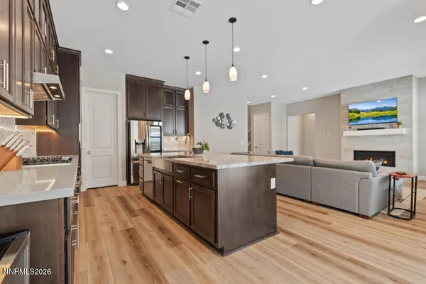 a large kitchen with stainless steel appliances granite countertop a large counter top a stove and a refrigerator