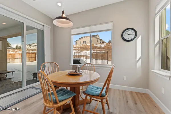 a dining room with furniture a large window and a rug