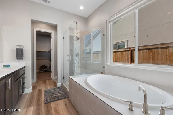 a bathroom with a tub a sink and a window