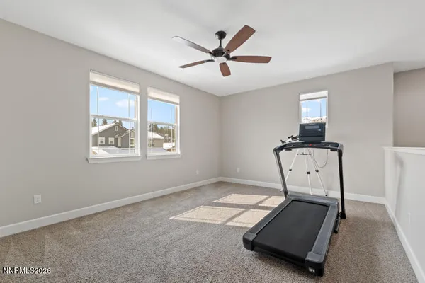 a room with gym equipment and a ceiling fan