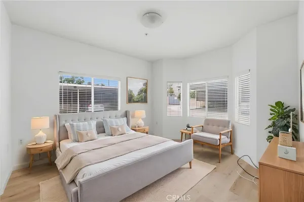 a bedroom with a large bed and a potted plant