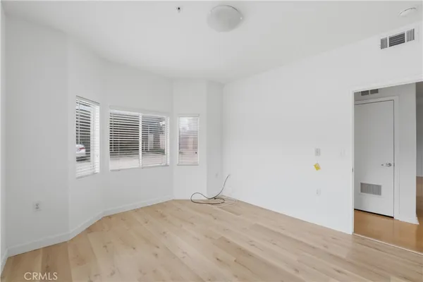 a view of empty room with wooden floor and windows