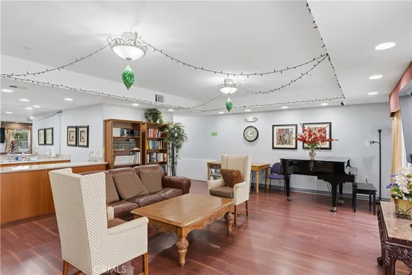 a view of living room kitchen island stainless steel appliances wooden floor and living room view