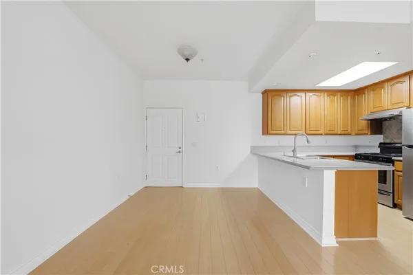 a kitchen with granite countertop a sink cabinets stainless steel appliances and a window