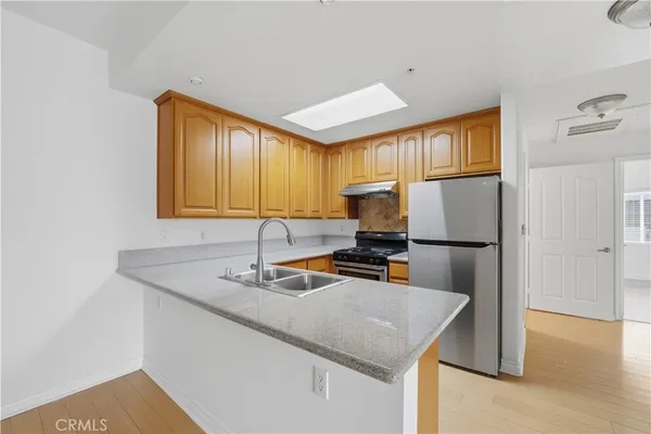 a kitchen with stainless steel appliances granite countertop a sink a refrigerator and a granite counter tops