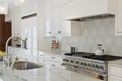 a view of kitchen with white cabinets and refrigerator