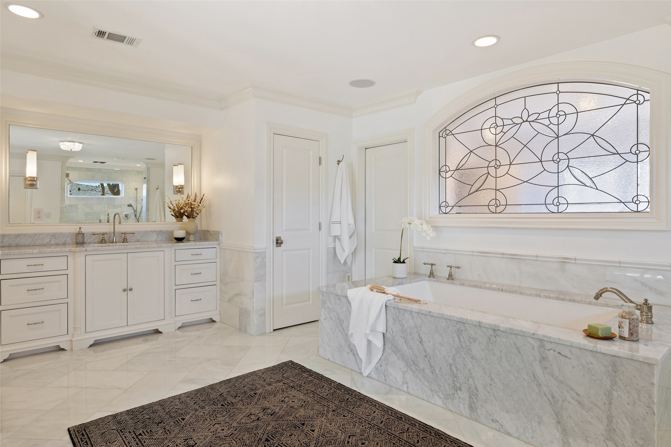 1810 West 35th Street Austin, TX 78703 - Photo 20 of 40 Set beneath an elegant leaded glass window, this marble-clad soaking tub creates a serene retreat.