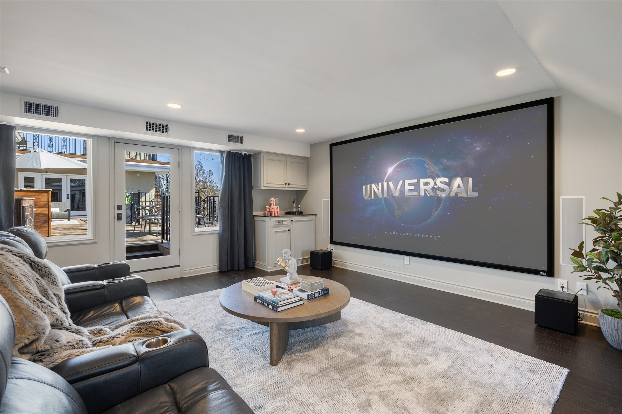 1810 West 35th Street Austin, TX 78703 - Photo 38 of 40 Spacious media room featuring a built-in projection screen, surround sound, and recessed lighting. Designed for movie nights and entertaining, with direct access to the outdoor living area and a convenient wet bar for added functionality.