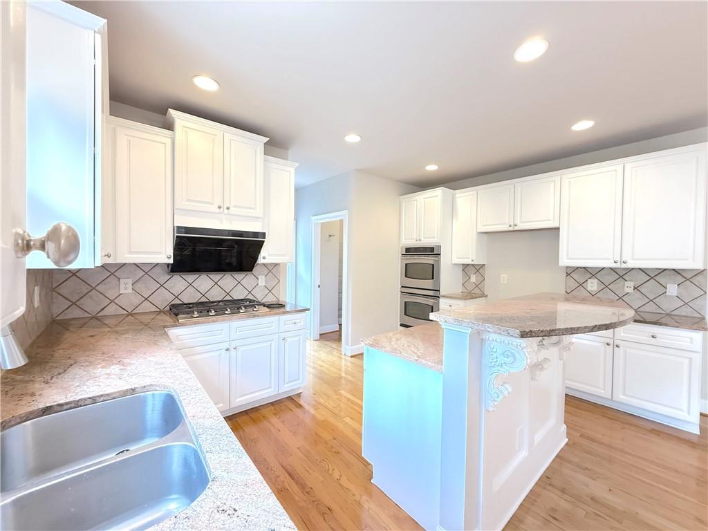 3500 Millwater Crossing Northeast Dacula, GA 30019 - Photo 21 of 72 a large kitchen with stainless steel appliances granite countertop a stove a sink and a granite counter tops with white cabinets