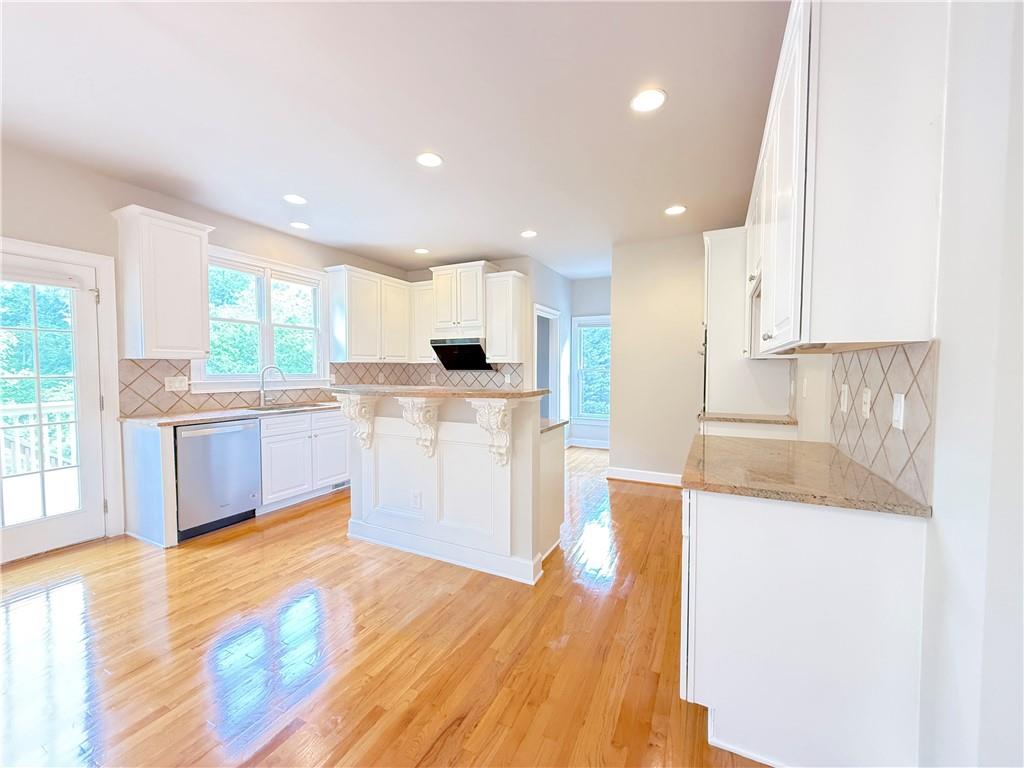 3500 Millwater Crossing Northeast Dacula, GA 30019 - Photo 22 of 72 a large kitchen with stainless steel appliances granite countertop a stove a sink dishwasher and a refrigerator with wooden floor