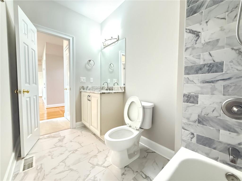 3500 Millwater Crossing Northeast Dacula, GA 30019 - Photo 25 of 72 a bathroom with a toilet sink and shower