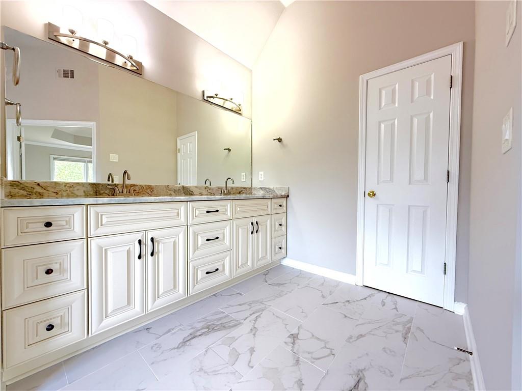 3500 Millwater Crossing Northeast Dacula, GA 30019 - Photo 30 of 72 a spacious bathroom with a granite countertop sink and a mirror