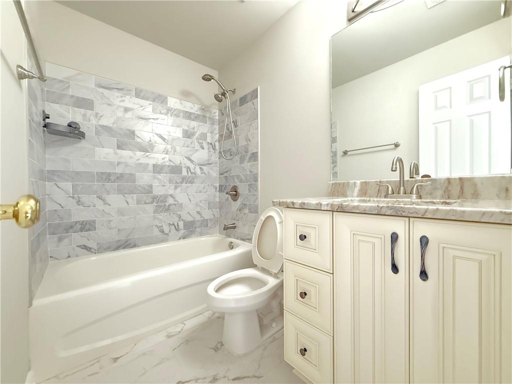 3500 Millwater Crossing Northeast Dacula, GA 30019 - Photo 36 of 72 a bathroom with a granite countertop sink toilet and shower