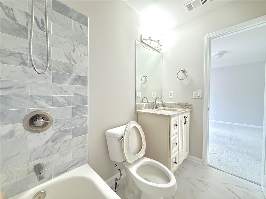 3500 Millwater Crossing Northeast Dacula, GA 30019 - Photo 39 of 72 a bathroom with a toilet sink shower and mirror